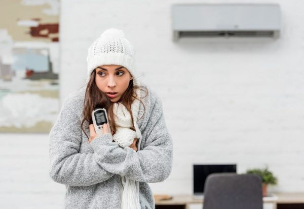 freezing-young-woman-in-warm-clothes-holding-remot-2022-02-08-05-31-59-utc-1024x683